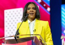 MAGA Darling Makes Her Biggest Political Break A woman in a yellow blazer speaking at a podium with a microphone