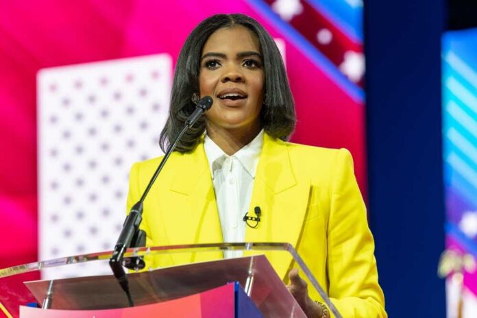 A woman in a yellow blazer speaking at a podium with a microphone