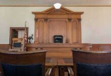 A 30-Year-Old Court Finally Faces Its First Test Judge's bench in a traditional courtroom with wooden paneling and empty seats