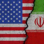 A High-Stakes Deadline Nears Its End Split image of United States and Iran flags divided by a cracked seam