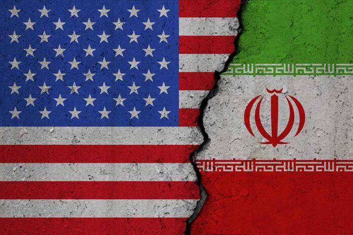 shutterstock_2376265565 Split image of United States and Iran flags divided by a cracked seam