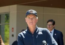 Newsom’s Tax Plan Targets America’s Wealthiest Politician speaking at a press conference outdoors