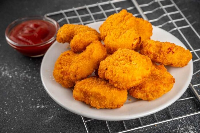 Traditional,Golden,Fresh,Fried,Chicken,Nuggets,On,A,Plate,,With Plate of golden chicken nuggets with a side of ketchup