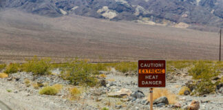 Warning sign about extreme heat in a rocky desert landscape