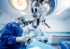 Surgeons performing operation under surgical microscope