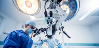 Surgeons performing operation under surgical microscope