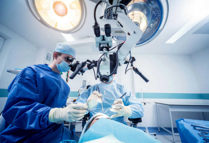 Surgeons performing operation under surgical microscope