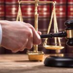 New Testimony Deepens Questions in Murder Trial Judge's hand holding gavel near scales of justice