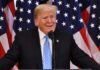 man at podium with U.S. flags behind him