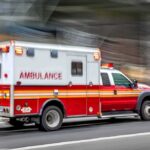 Ambulance speeding down a city street with lights flashing