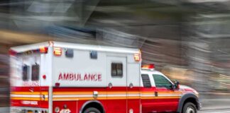 Ambulance speeding down a city street with lights flashing
