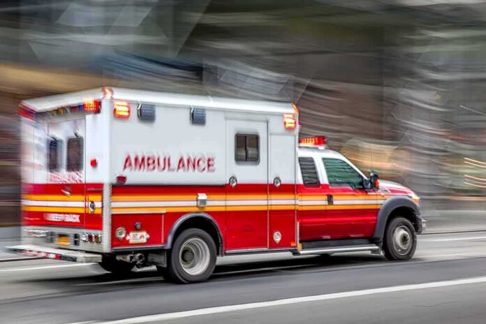 Ambulance speeding down a city street with lights flashing