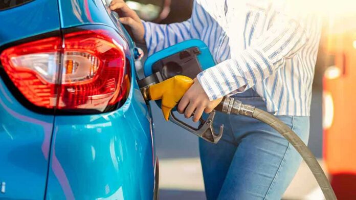 Person refueling a blue car with a yellow gas nozzle