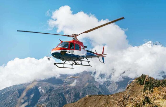 shutterstock_1559879972 helicopter flying over mountain landscape
