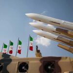 Iran’s Victory Lap Runs Into an Awkward Reality Missile launchers on a military vehicle with flags in the background