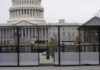 US Capitol behind security fence with guards