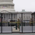 US Capitol behind security fence with guards