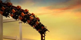 roller coaster train rounding a curve at sunset