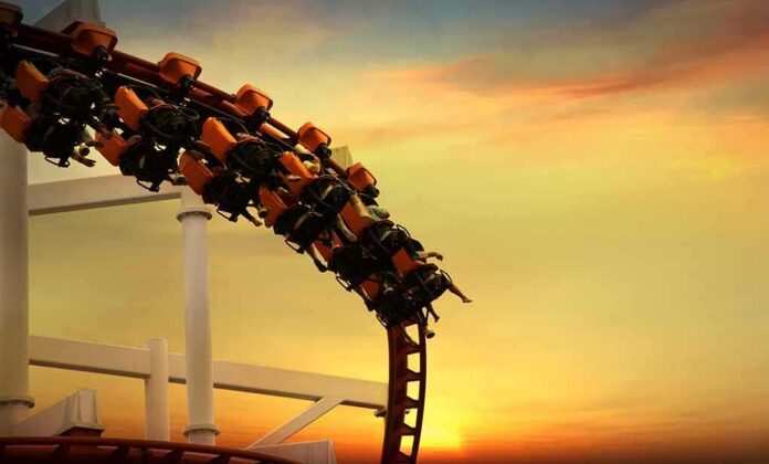 roller coaster train rounding a curve at sunset