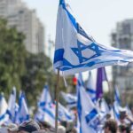 Election Showdown Spills Onto Israel’s Streets Israeli flags waved at a street demonstration