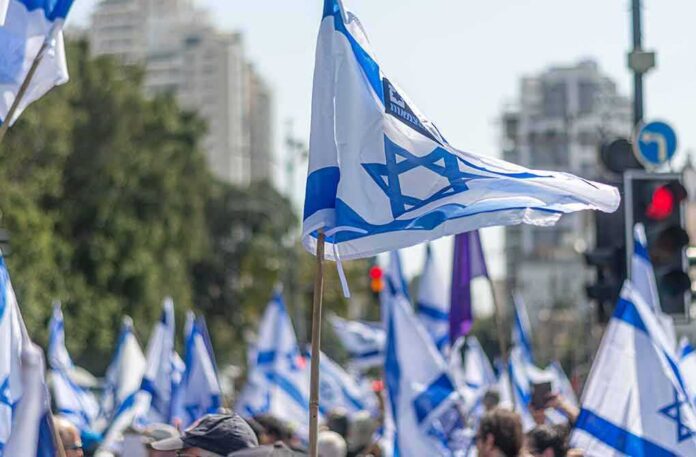 shutterstock_2269386315 Israeli flags waved at a street demonstration