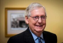 Resign Or Reveal? Kentucky Standoff elderly man wearing glasses and a suit smiling