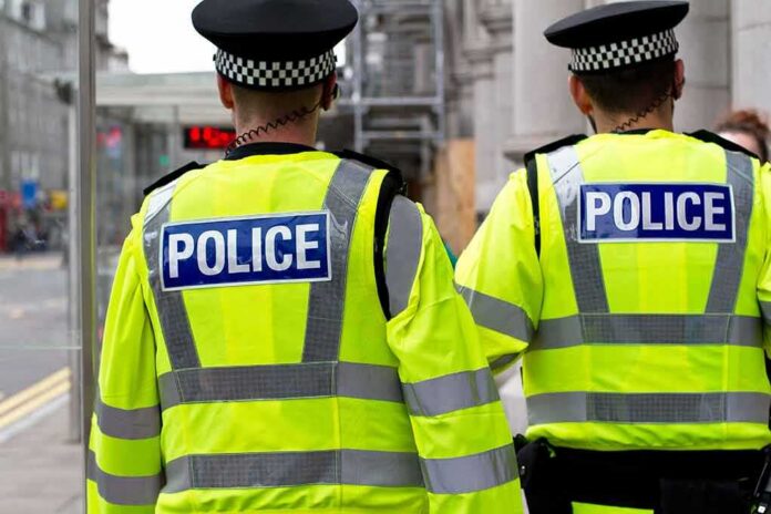 Two police officers in high-visibility jackets walking on a city street