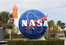 NASA globe sign at visitor center with space shuttle booster in background
