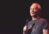 comedian holding a microphone on stage