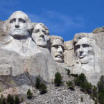 Mount Rushmore with four presidential faces carved in rock.