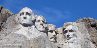 Mount Rushmore with four presidential faces carved in rock.