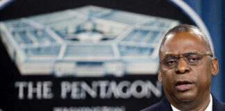 Lloyd Austin speaking at a podium in front of a Pentagon emblem