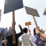 Group of people holding protest signs outdoors