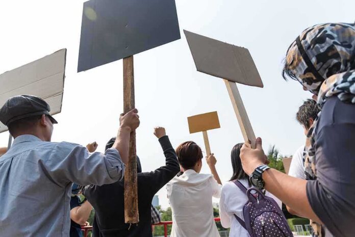 Group of people holding protest signs outdoors