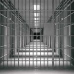 Public Safety Gamble – Who Let Them Out? empty prison corridor with barred cells
