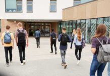 Students with backpacks walking toward a school entrance