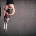 hand holding a handgun at side
