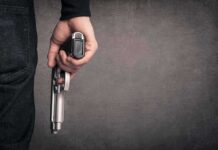 hand holding a handgun at side