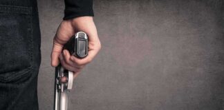 hand holding a handgun at side