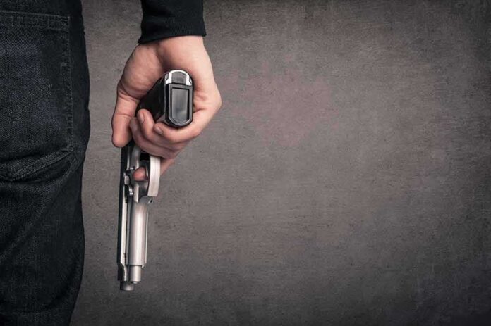 shutterstock_126668459 hand holding a handgun at side