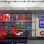 CNN newsroom set with red chairs and multiple TVs