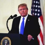 Stunning Cross-Party Vote Kills Impeachment man at podium with microphone and US flag