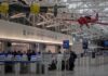 airport security checkpoint with passengers and hanging vintage airplanes