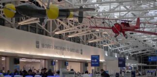 airport security checkpoint with passengers and hanging vintage airplanes