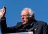 Bernie Sanders speaking at a podium outdoors