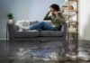 Man on couch calling for help during home flooding