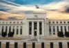 Neoclassical government building with American flag at sunset