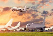 A Hidden Weakness Lurks Inside America’s Cockpits Passenger jets on airport tarmac with one aircraft landing at sunset