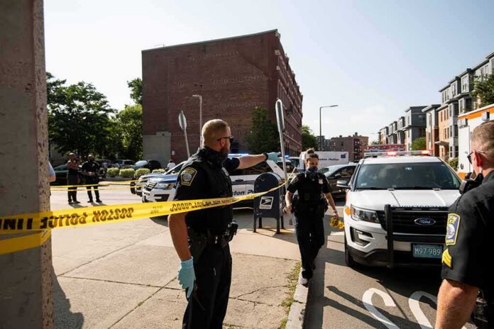 Police officers secure an urban street with yellow tape near patrol cars