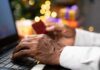 Hands using a laptop and holding a credit card